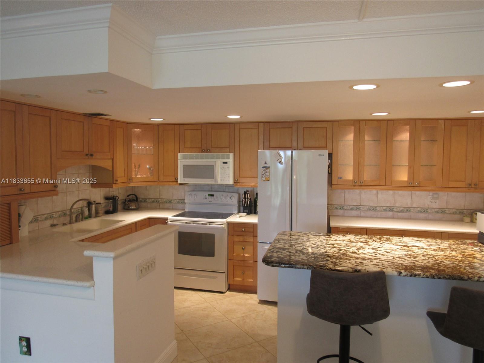 1101 River Reach Drive, Unit 418 Fort Lauderdale, FL 33315 - Photo 7 of 54 a kitchen with stainless steel appliances granite countertop a sink stove and refrigerator