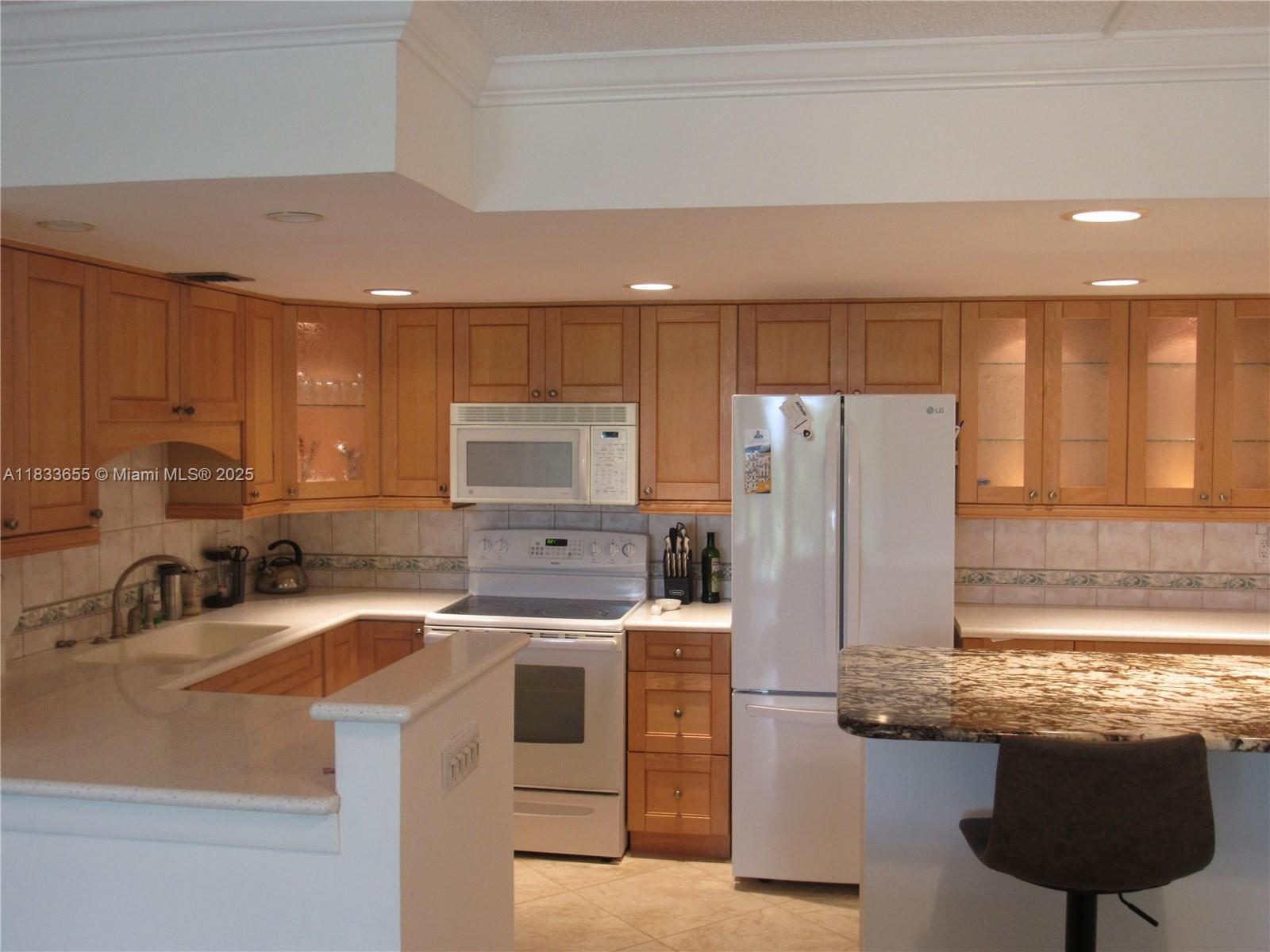 1101 River Reach Drive, Unit 418 Fort Lauderdale, FL 33315 - Photo 8 of 54 a kitchen with stainless steel appliances a sink a stove a refrigerator cabinets and a counter top space