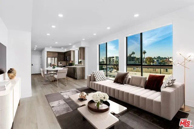a living room with furniture and view of kitchen