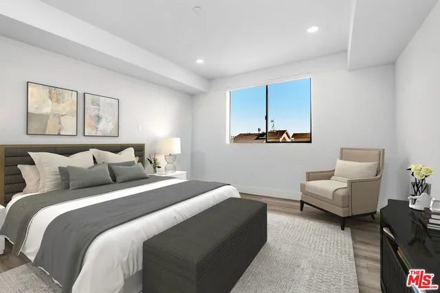 a bedroom with a bed couch and painting on the wall