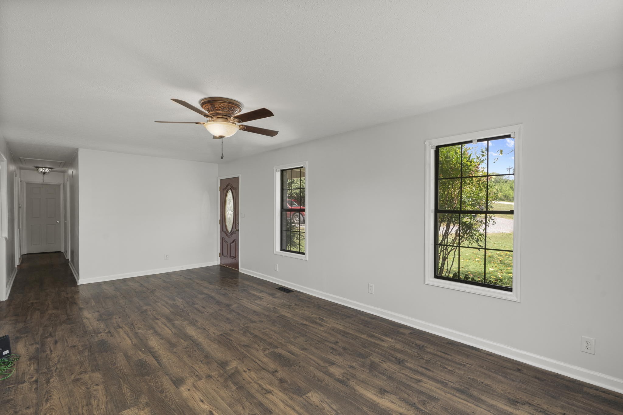 450 Fowler Ford Road Portland, TN 37148 - Photo 6 of 20 an empty room with wooden floor chandelier fan and windows