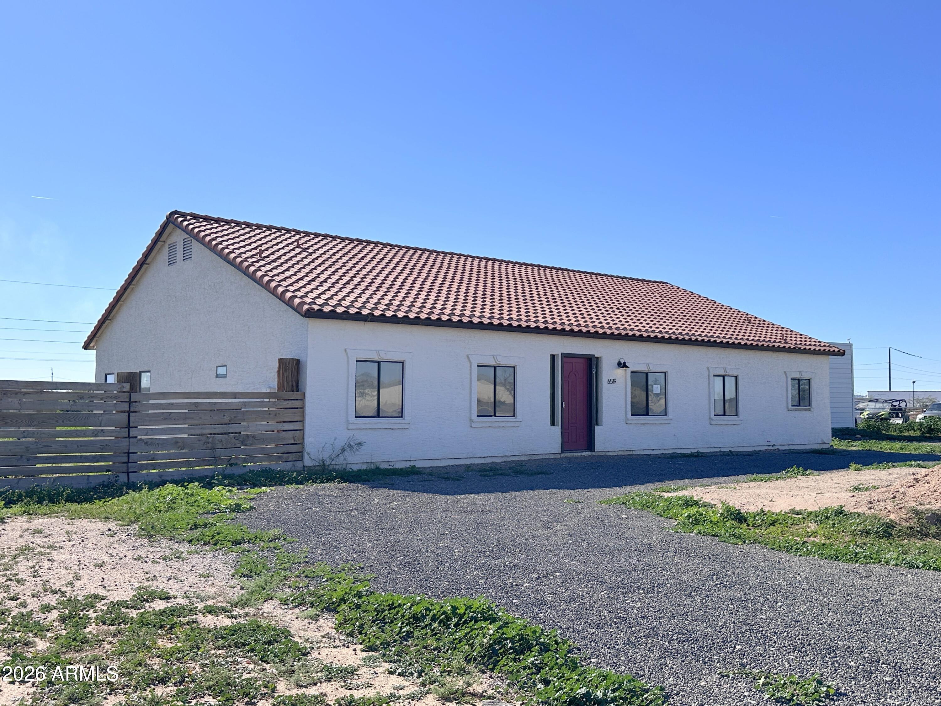 a view of house with backyard and wooden fence
