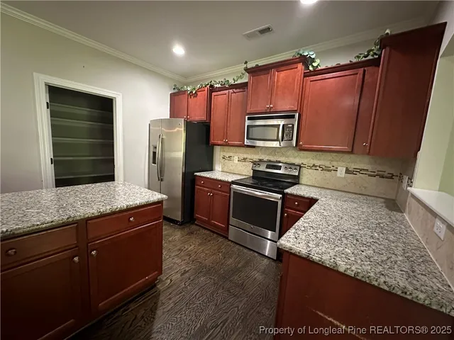 a kitchen with stainless steel appliances granite countertop a refrigerator stove and oven