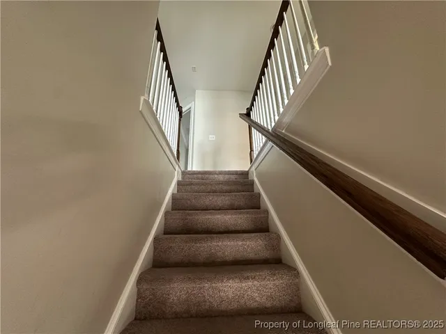 a view of a hallway with a livingroom and a bathroom with sink