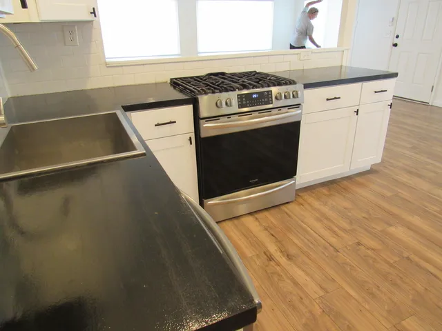 a kitchen with stainless steel appliances granite countertop a sink stove and refrigerator
