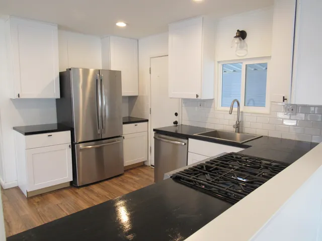 a large white kitchen with a large window