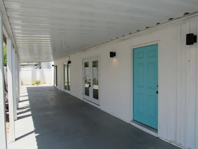 a view of a hallway with entryway and hall with wooden floor