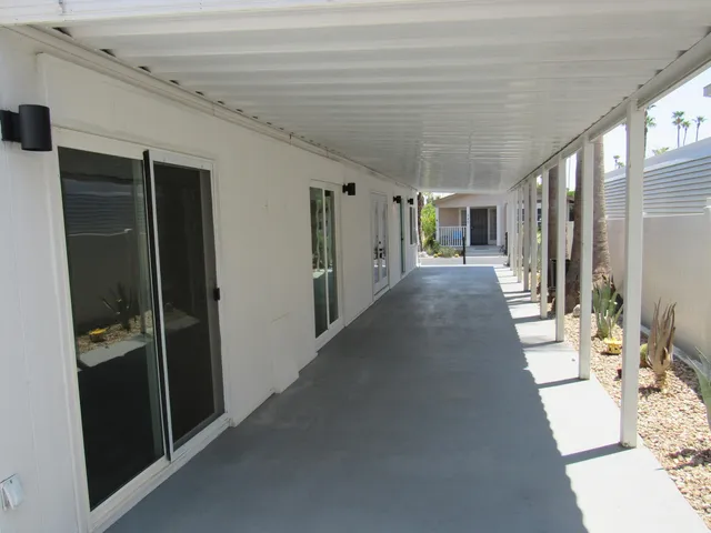 a view of a hallway with bathroom and wooden floor