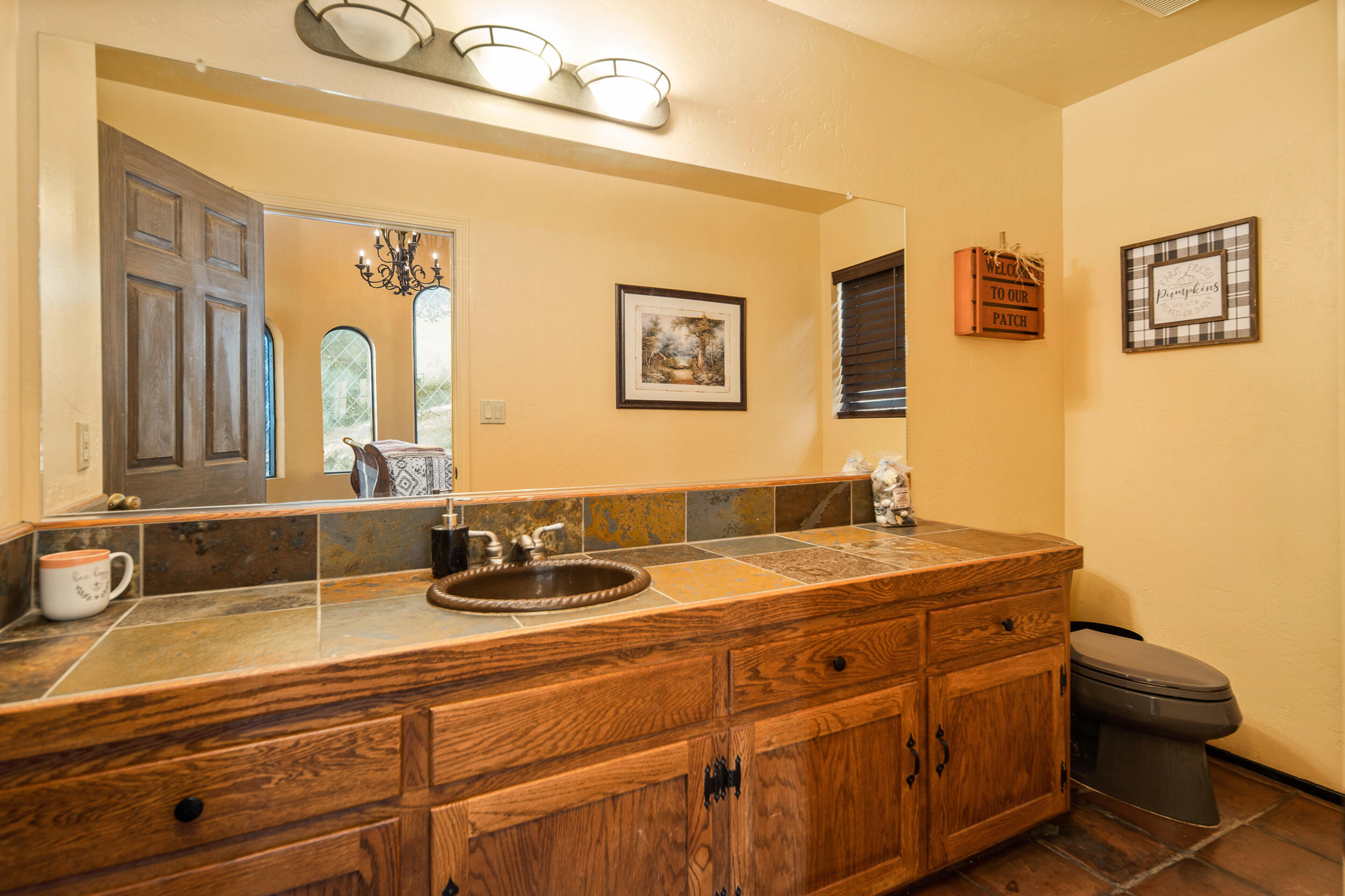 20718 Darsy Road Tehachapi, CA 93561 - Photo 33 of 64 a bathroom with a granite countertop sink a toilet and a mirror