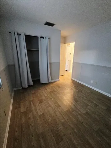 a view of empty room with closet and wooden floor