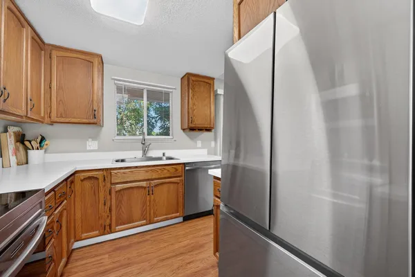 a kitchen with a sink a refrigerator and cabinets