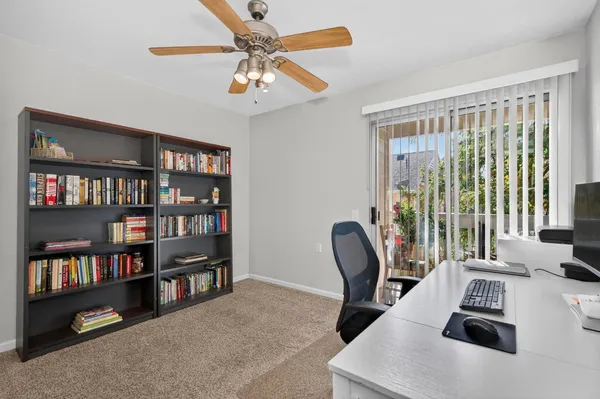 a living room with furniture a bookshelf and a window