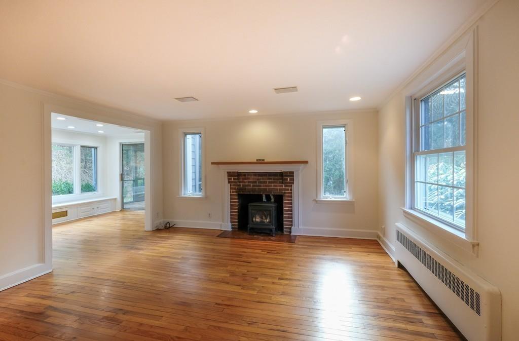 53 Moore Road Wayland, MA 01778 - Photo 3 of 27 an empty room with wooden floor fireplace and windows