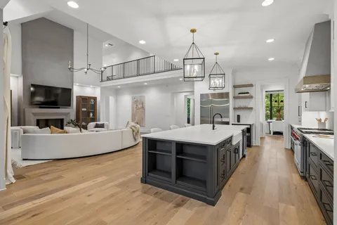 a living room with furniture a fireplace and floor to ceiling window
