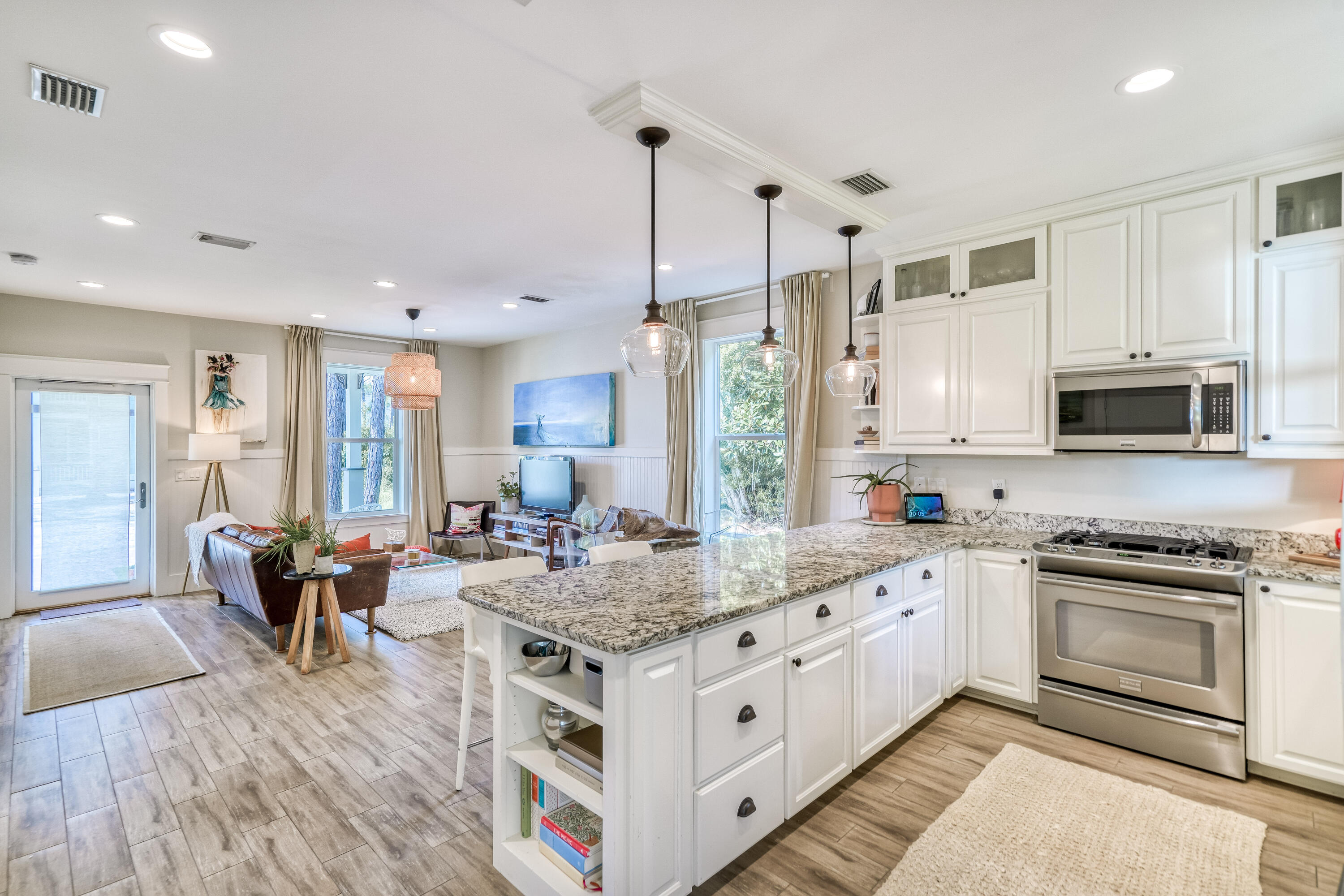 100 Snapper Street Santa Rosa Beach, FL 32459 - Photo 7 of 35 a kitchen with stainless steel appliances granite countertop a stove top oven a sink dishwasher a dining table and chairs with wooden floor