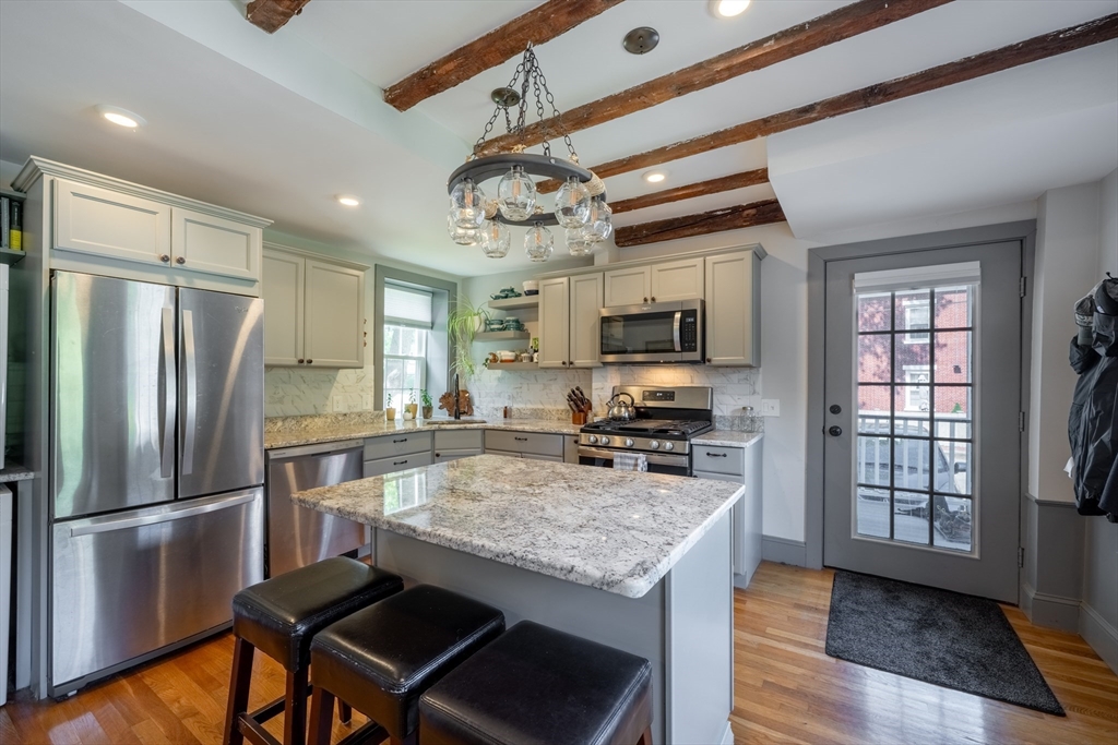 8 Williams Street, Unit E1 Salem, MA 01970 - Photo 6 of 30 a kitchen with stainless steel appliances granite countertop a refrigerator a stove microwave and island