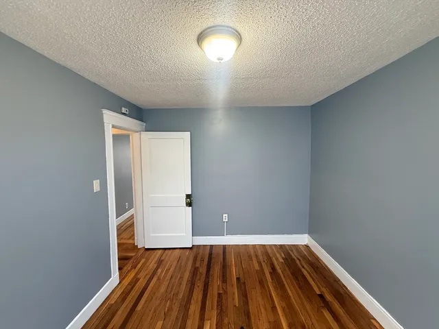 a view of a room with wooden floor and window