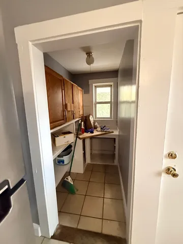 a view of an empty room with closet and a window