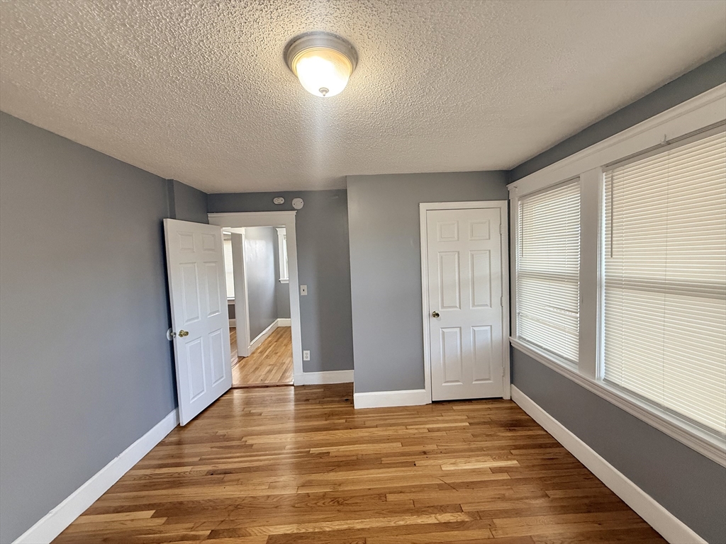 39 Wentworth Street, Unit 3 Boston, MA 02124 - Photo 10 of 19 a view of an empty room with window and wooden floor