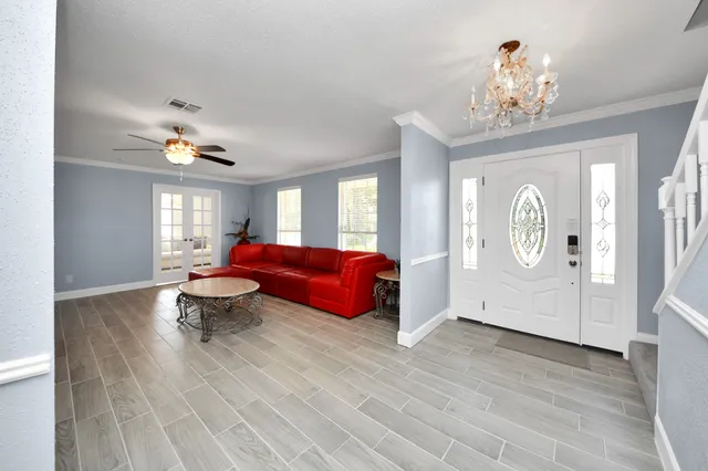 a living room with furniture chandelier and a window