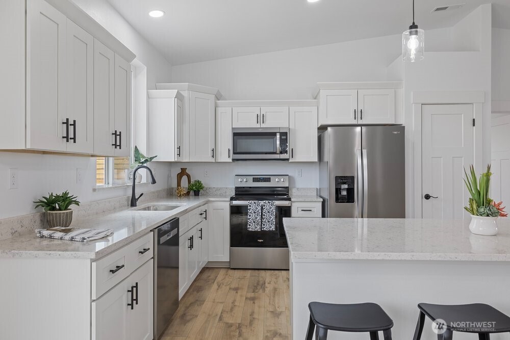 334 Spring Circle Mattawa, WA 99349 - Photo 5 of 40 a kitchen with white cabinets and stainless steel appliances