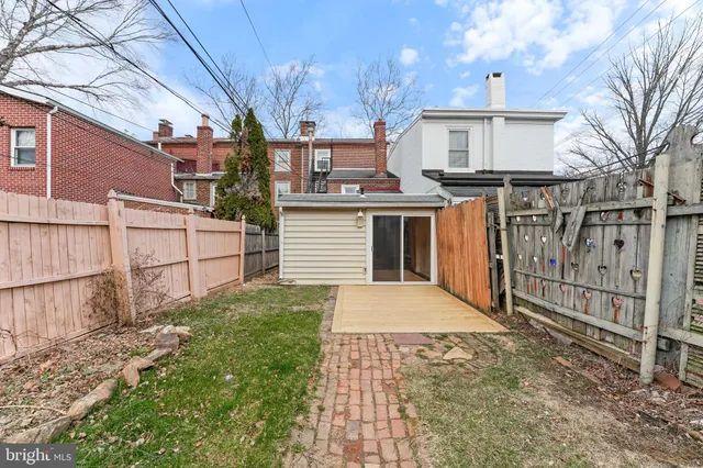 a white house that has tree in front of it