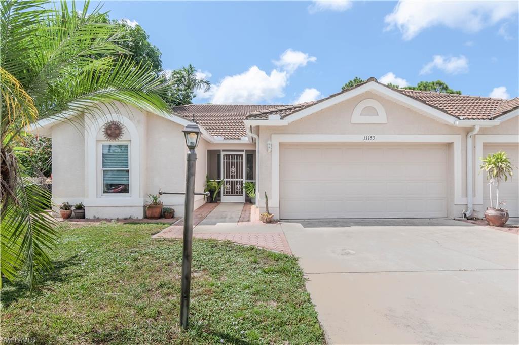 11153 San Sebastian Lane Bonita Springs, FL 34135 - Photo 1 of 25 a front view of a house with a yard and garage