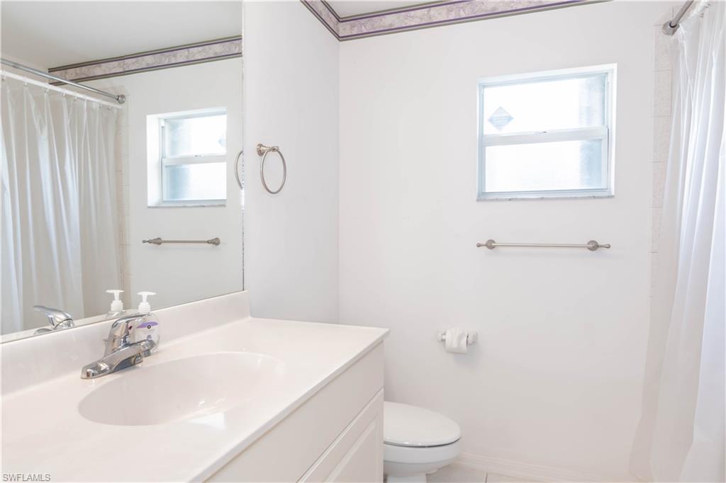 11153 San Sebastian Lane Bonita Springs, FL 34135 - Photo 23 of 25 a bathroom with a granite countertop sink a toilet and shower