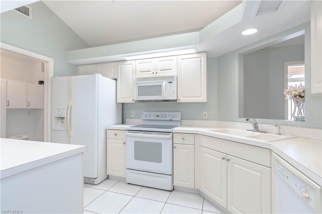 11153 San Sebastian Lane Bonita Springs, FL 34135 - Photo 8 of 25 a kitchen with white cabinets and white appliances