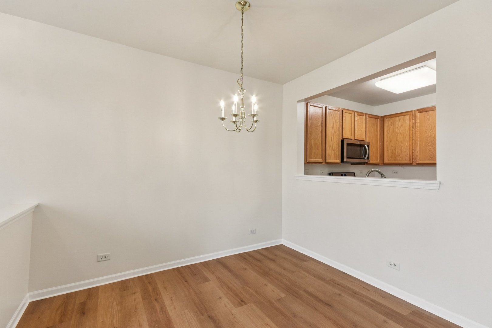 2486 Georgetown Circle Aurora, IL 60503 - Photo 7 of 26 a view of a room with wooden floor and chandelier
