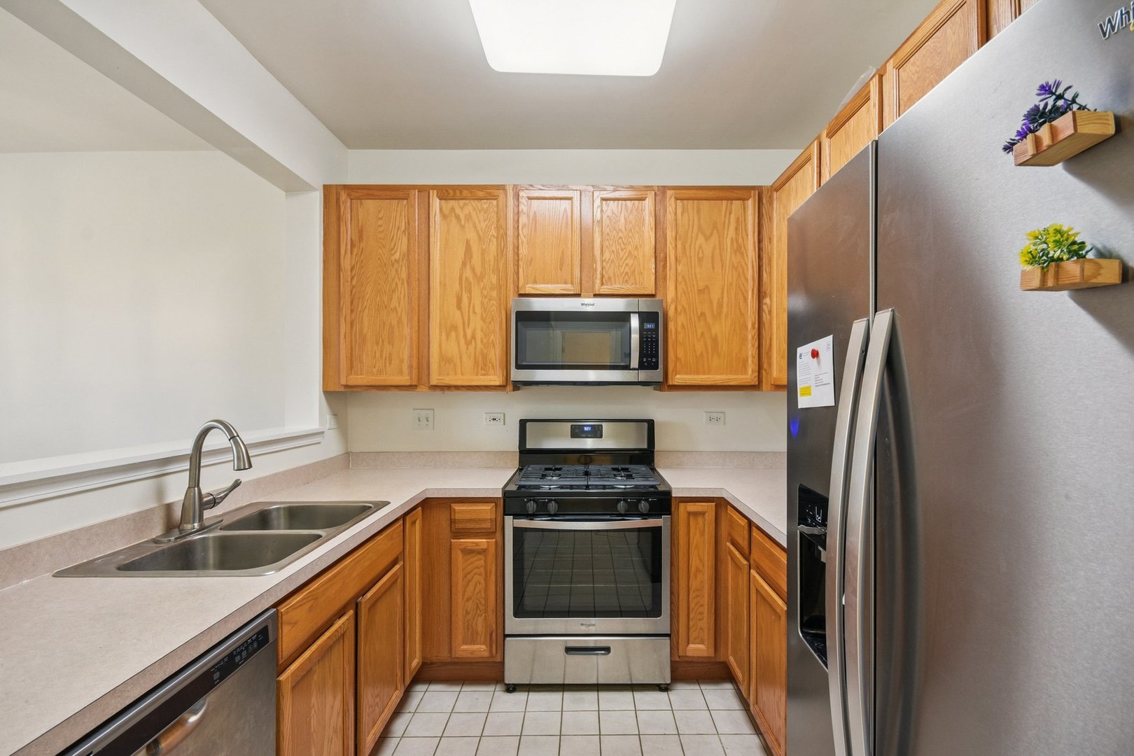 2486 Georgetown Circle Aurora, IL 60503 - Photo 8 of 26 a kitchen with a sink a refrigerator and a stove top oven