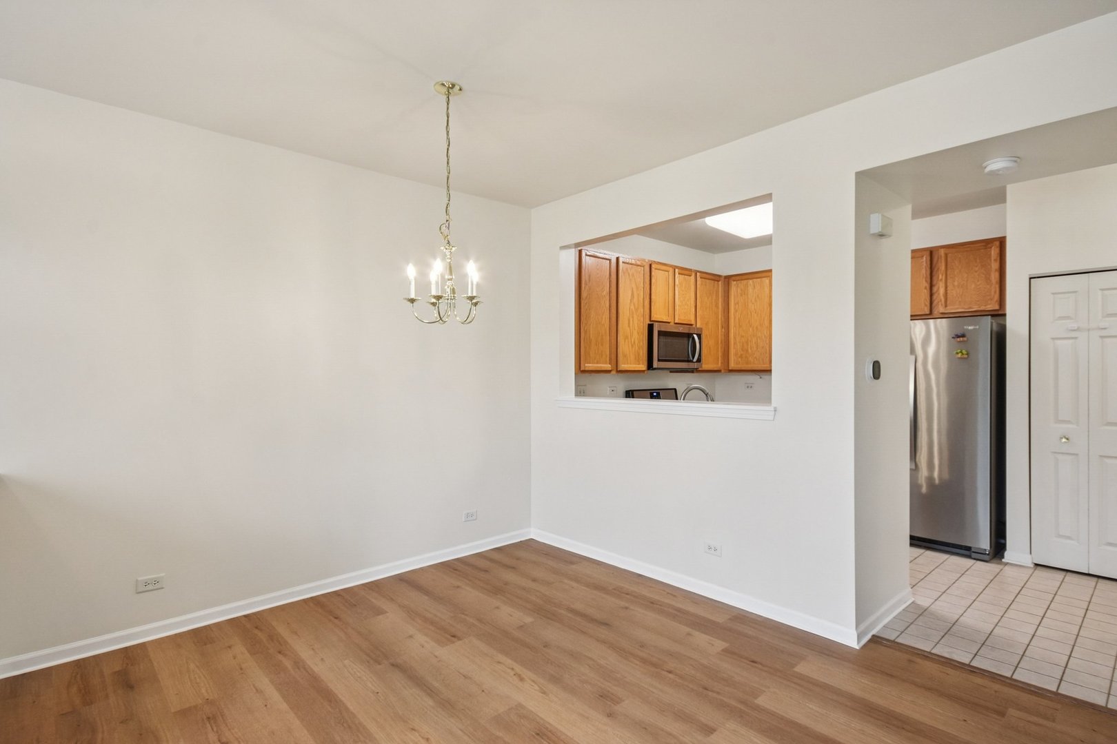 2486 Georgetown Circle Aurora, IL 60503 - Photo 10 of 26 a view of a room with wooden floor and chandelier