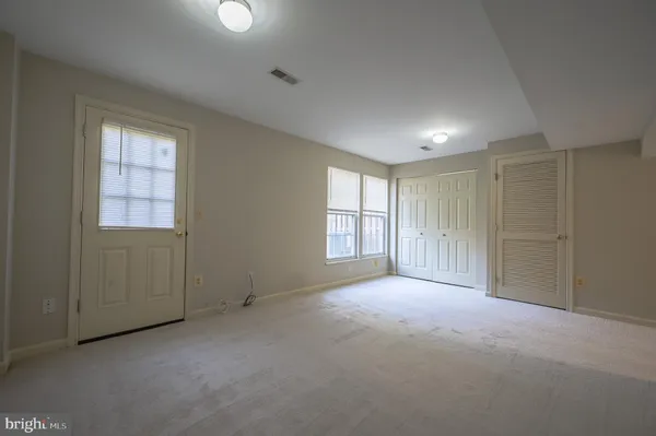 an empty room with windows and closet