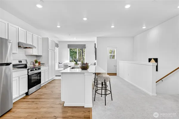 a kitchen with white cabinets and stainless steel appliances
