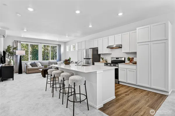 a kitchen with white cabinets and stainless steel appliances