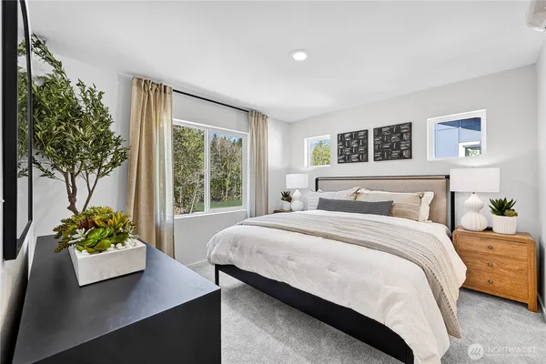 a bedroom with a bed potted plant on the dresser and a window
