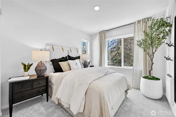 a bedroom with bed and a potted plant