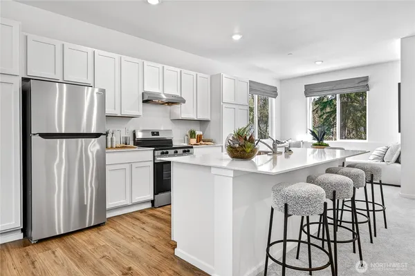 a kitchen with white cabinets and stainless steel appliances