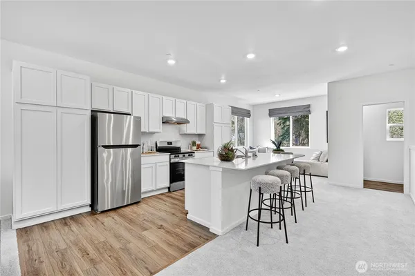 a kitchen with white cabinets and stainless steel appliances