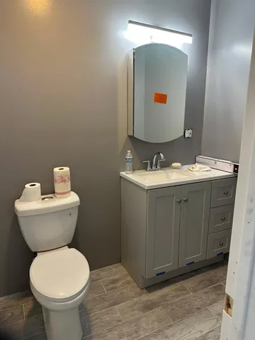 a bathroom with a toilet sink and mirror