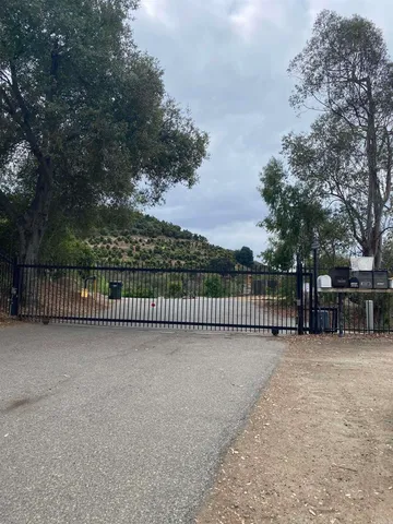a view of a fence and trees in the background