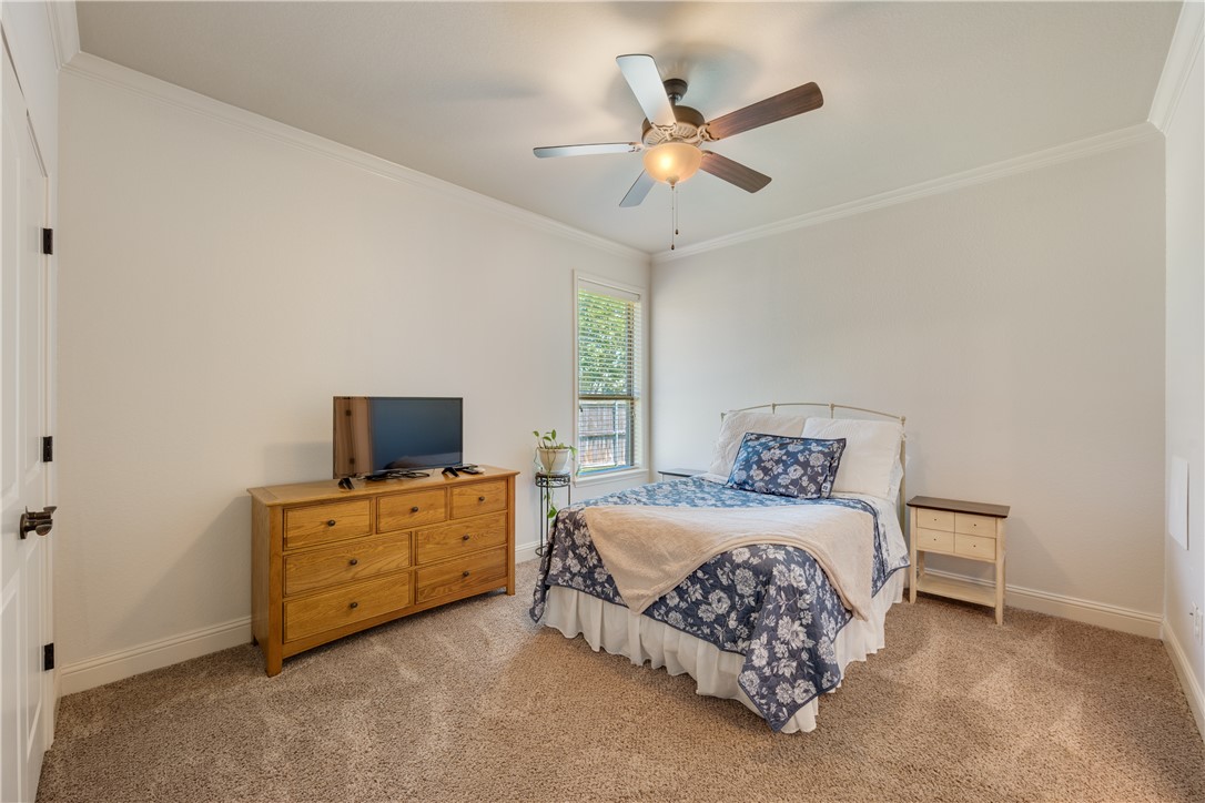 3301 Covington Court Bryan, TX 77808 - Photo 18 of 26 a bedroom with a bed and a flat tv screen on dresser