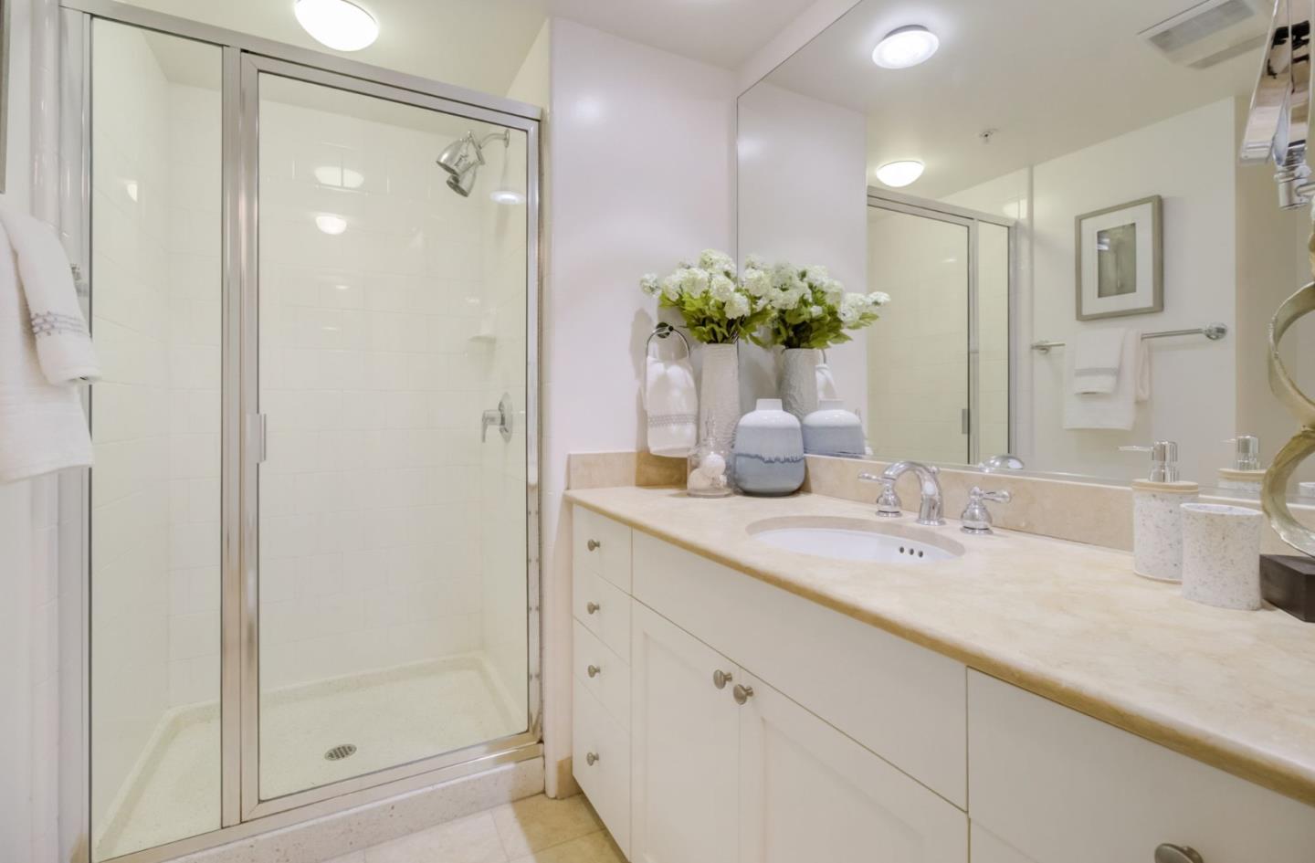 400 Beale Street, Unit 612 San Francisco, CA 94105 - Photo 24 of 38 a bathroom with a granite countertop sink a mirror and a shower
