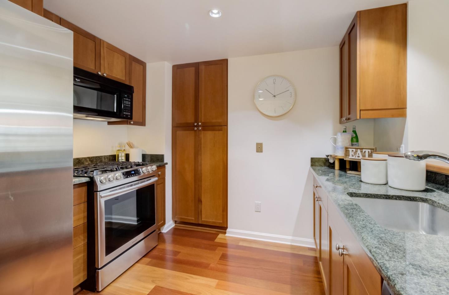 400 Beale Street, Unit 612 San Francisco, CA 94105 - Photo 10 of 38 a kitchen with stainless steel appliances granite countertop a sink a stove and a microwave oven