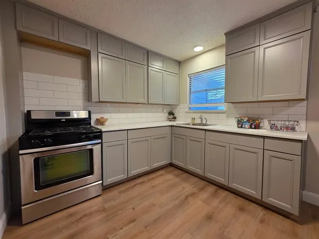 a kitchen with a sink stove and cabinets