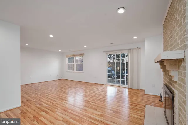 an empty room with wooden floor and a fireplace