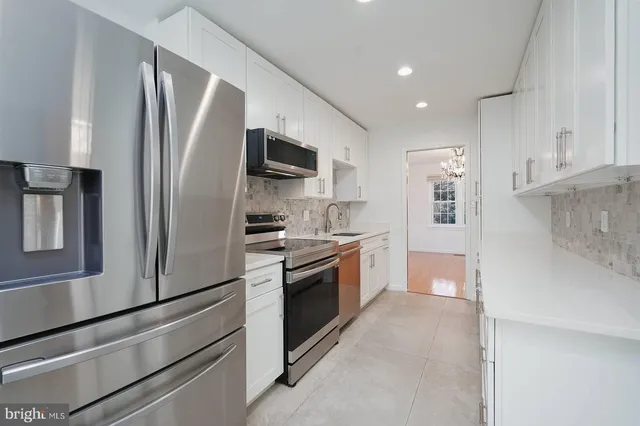 a large kitchen with stainless steel appliances and chandelier