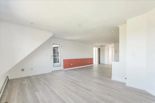 a view of an empty room with wooden floor