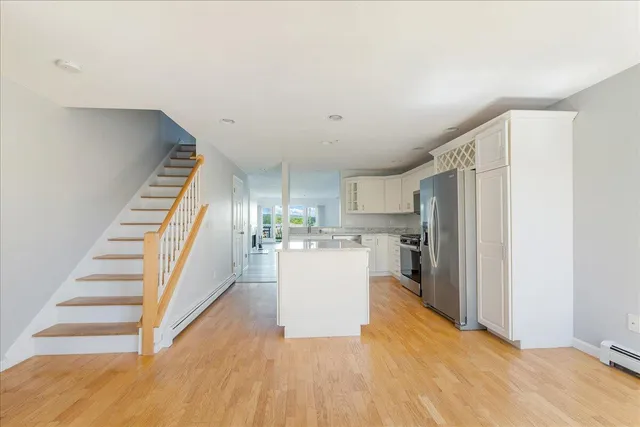 a view of a kitchen with wooden floor and electronic appliances