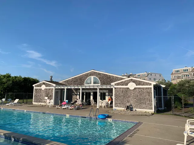 an aerial view of a house with swimming pool and outdoor seating